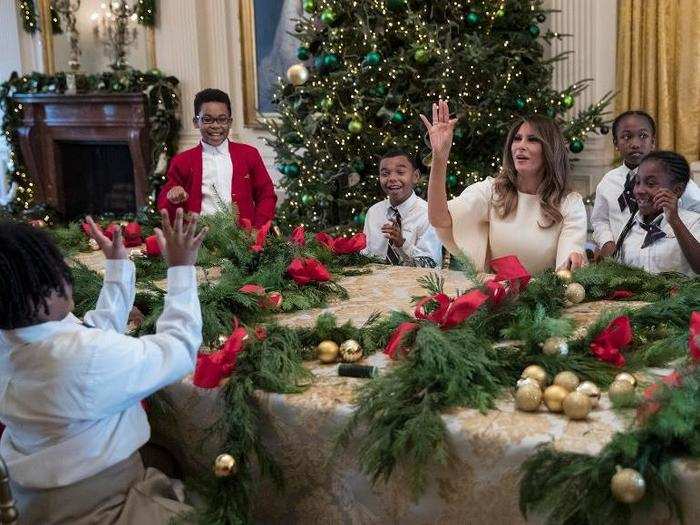 She spent time constructing wreaths with kids in the East Room. Here she is tossing a golden ornament to one of them. Hope it didn