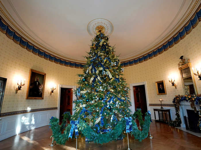 The official Christmas Tree stands tall and regal in the White House Blue Room. It is decorated with the seals of every US state and territory.