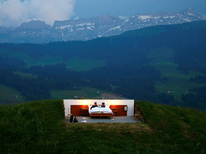 Two people pose as guests in the bedroom of the Null-Stern-Hotel (Zero-star-hotel) art installation by Swiss artists Frank and Patrik Riklin on Saentis near Gonten, Switzerland. Guests can order overnight stays in the Null-Stern hotel room, located on some 3,937-foot altitude in the eastern Swiss Alps.