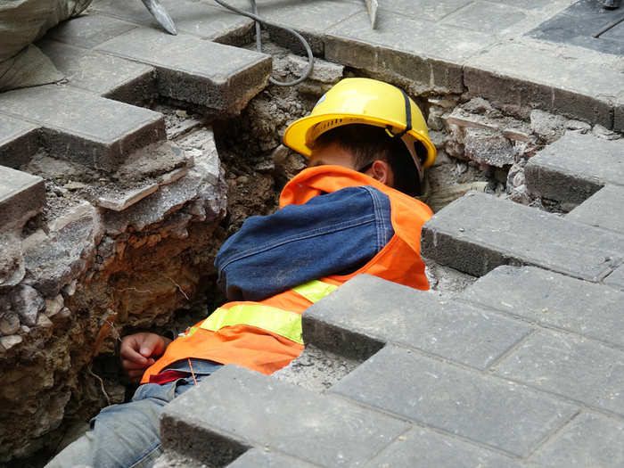 A construction worker rests in a ditch at a roadside on a chilly day in Guiyang city, Guizhou province, China.