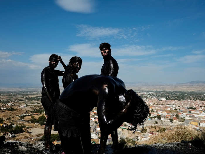 A reveler puts grease on his body as he takes part in the annual Cascamorras festival in Baza, southern Spain. The festival was inspired by a dispute between the town of Baza and Guadix over the possession of an icon of the Virgin of Piedad. The Cascamorras refers to representatives from Guadix, who were sent to Baza to recover the statue. As the Cascamorras had to stay perfectly clean to gain possession of the statue, Baza residents attempt to make them as dirty as possible.