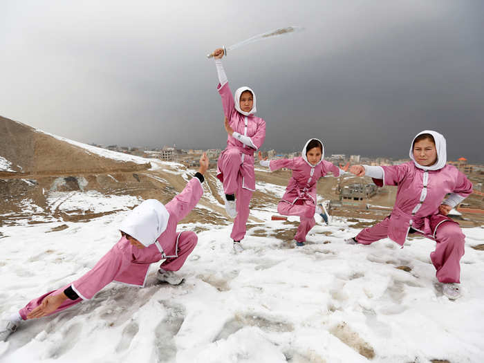 Hanifa Doosti, 17, and other students of the Shaolin Wushu club show their Wushu skills to other students on a hilltop in Kabul, Afghanistan.