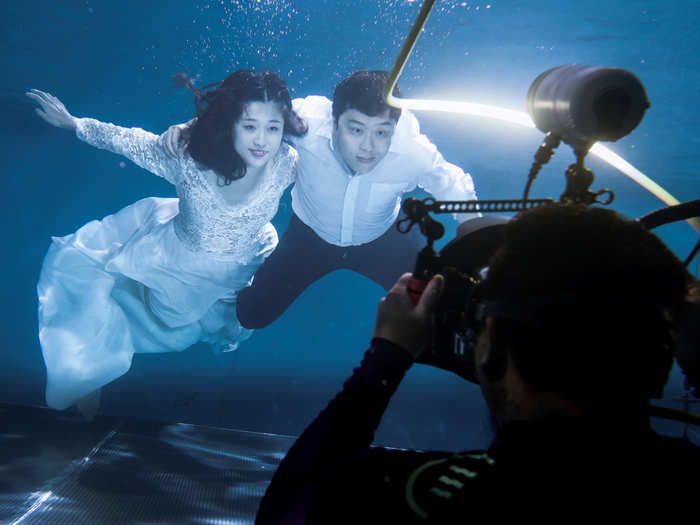 A couple has a wedding photograph taken in a pool at the Qianyishi Underwater Photography Studio in Beijing, China.