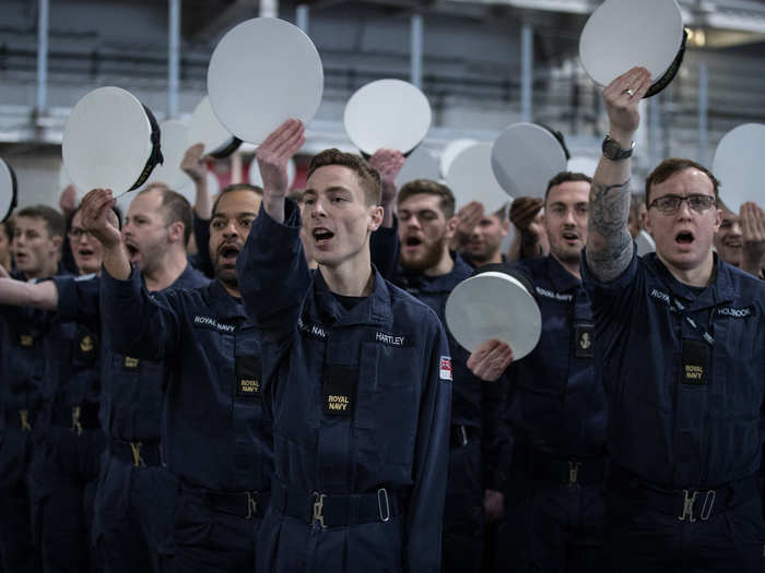 Senior non-commissioned officers yelled instructions while the junior sailors snapped to attention and practiced cheering for the Queen.