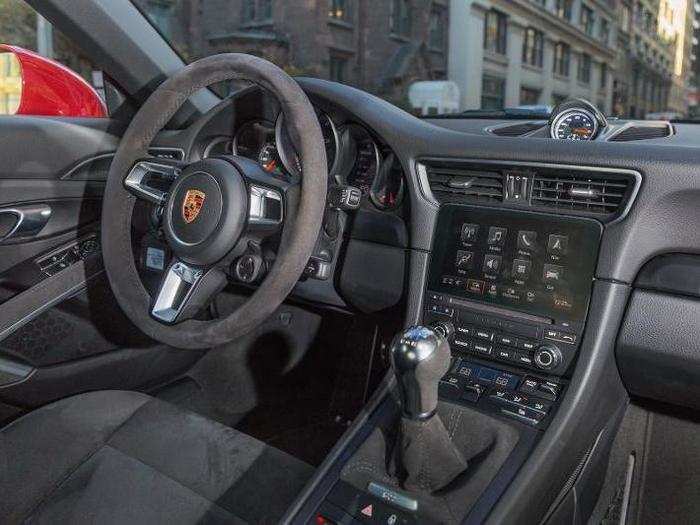 The cockpit is luxurious but no-nonsense — black Alcantara, brushed metal, and a purposeful steering wheel.