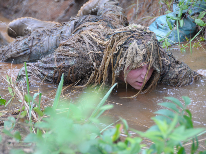 The first test of their new concealment comes hours later, crawling hundreds of feet through tall grass and a ditch filled with water, mud, rocks, and vegetation.