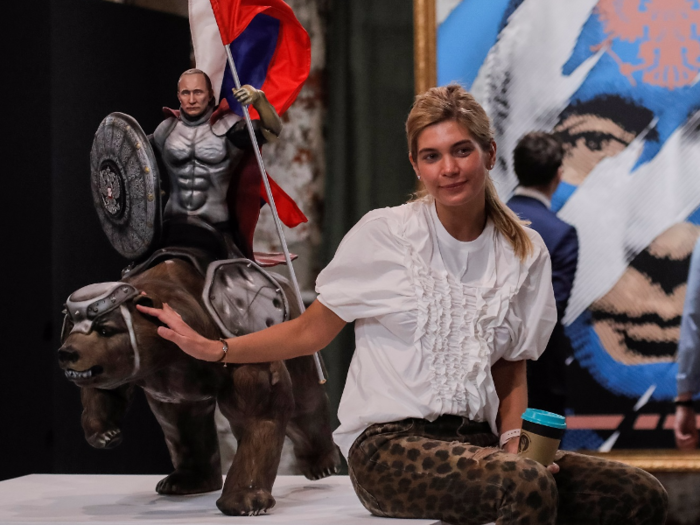 A heroic mini-Putin sculpture rides a bear in full body armor.