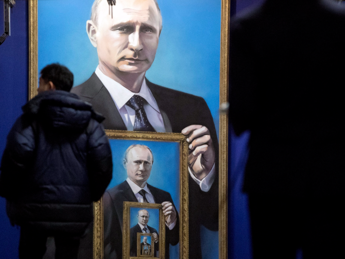 Another painting shows Putin holding frames of smaller Putins, but it