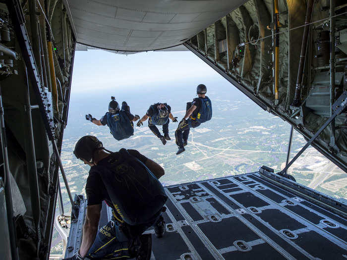 Members of the Leap Frogs, a US Navy Parachute Team, jump out of a C-130 Hercules during a skydiving demonstration above Biloxi High School on April 6.