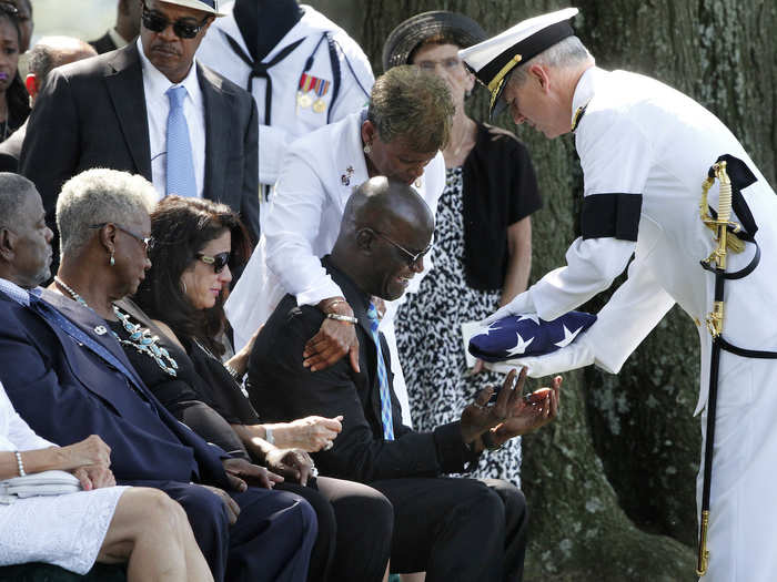 Darrold Martin is presented with a flag on August 9 by Navy Vice Adm. Thomas Moore during the funeral for his son, Petty Officer Xavier Alec Martin, who was aboard the USS Fitzgerald.