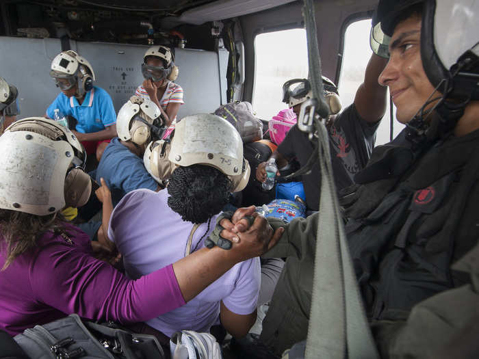 A Naval aircrewman comforts a Puerto Rican evacuee following the landfall of Hurricane Maria on September 25.