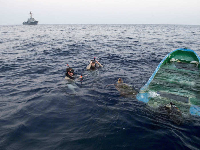 US Navy search and rescue swimmers assigned to the USS Howard save a loggerhead sea turtle entangled in a half-sunken fishing boat on October 16.