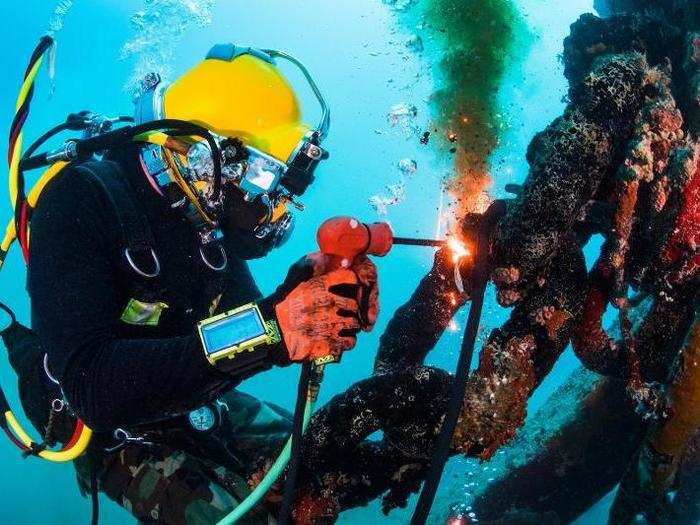 A US Navy diver performs underwater cutting operations using a Broco torch on a mooring system in Guam on December 12.