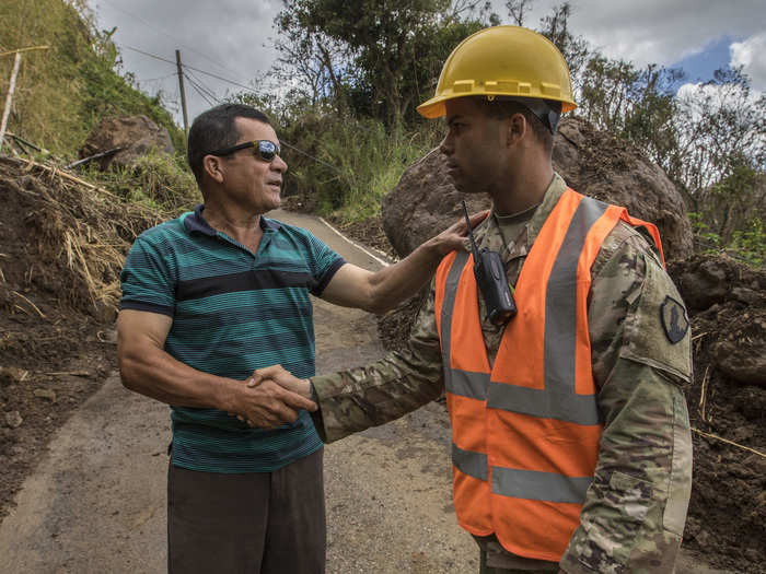 US Army reservist shakes hands with a local citizen while coordinating road clearing operations in Puerto Rico after Hurricane Maria on Oct. 7.