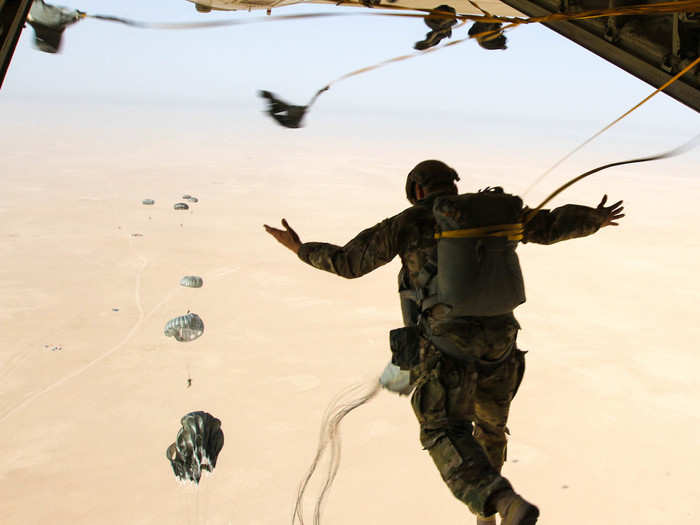 A K-9 handler for the Group Support Battalion 7th Special Forces Group leaps from the back of the aircraft on October 17.