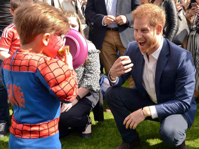 Summer brings with it garden party season — here Prince Harry eggs on a young-looking Spider-Man to get stuck in to his slice of cake at a Buckingham Palace party for children whose parents were killed while in the UK armed forces.