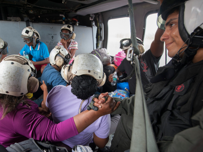 A Naval aircrewman comforts a Puerto Rican evacuee following the landfall of Hurricane Maria on September 25.