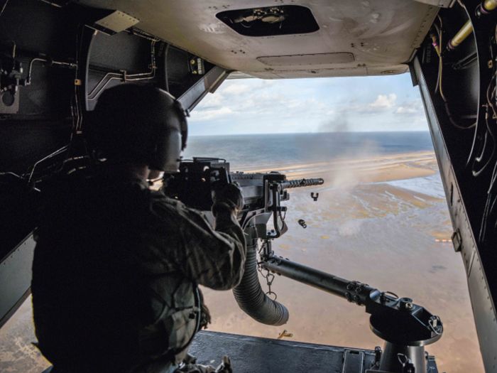 An air commando from the 7th Special Operations Squadron fires a .50-caliber machine gun aboard a CV-22 Osprey during a flight around southern England on September 11.