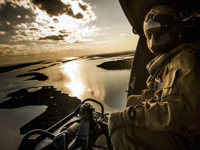 A crew chief assigned to Marine Light Attack Helicopter Squadron 167 observes the landing zone from a UH-1Y Huey during a training operation at Marine Corps Auxiliary Landing Field Bogue in North Carolina on March 9.