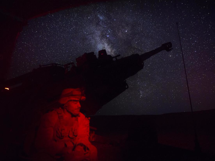 A Marine waits to conduct a fire mission in Syria early on June 3.