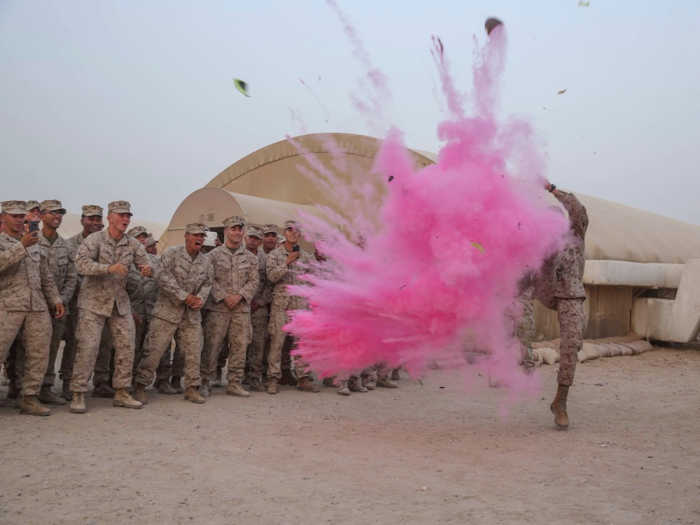 Capt. Gregory Veteto, of Company A, 1st Battalion, 5th Marine Regiment of the 15th Marine Expeditionary Unit, punts a football sent by his wife revealing the sex of his baby during a weekly formation on November 1.