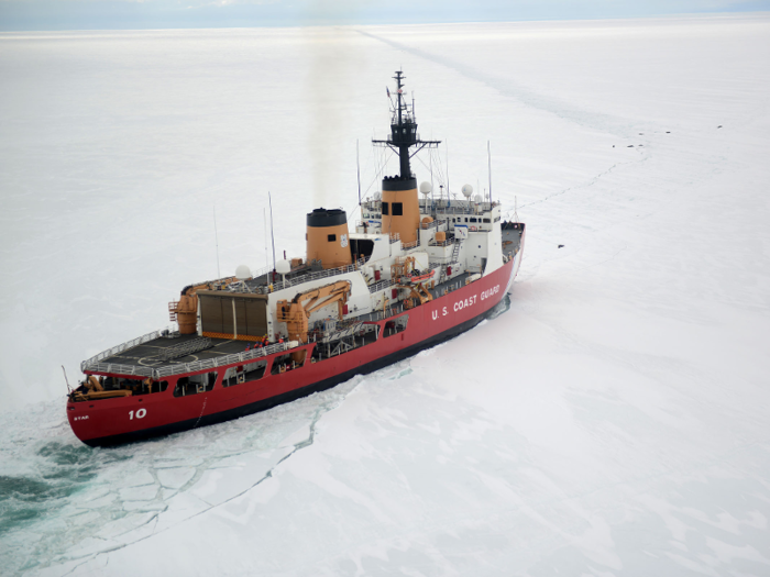 The Coast Guard Cutter Polar Star cuts through Antarctic ice in the Ross Sea near a large group of seals as the ship