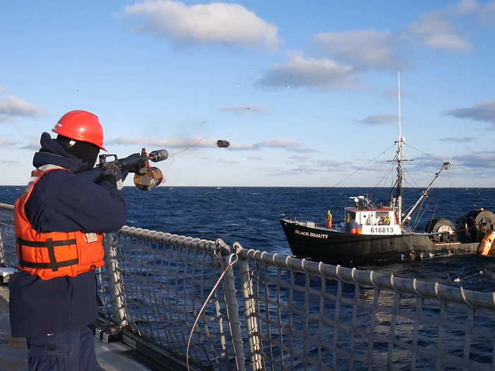 Petty Officer 3rd Class Anderson Ernst uses a line-throwing gun to help pass the tow line to 65-foot fishing trawler Black Beauty, off the coast of New Hampshire on November 11.