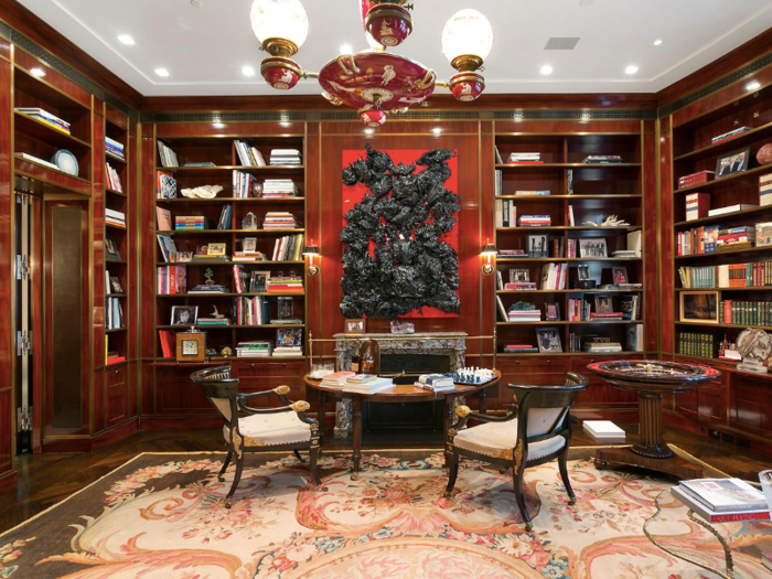 Opposite the master suite is a custom built wood-paneled library and ventilated smoking room.