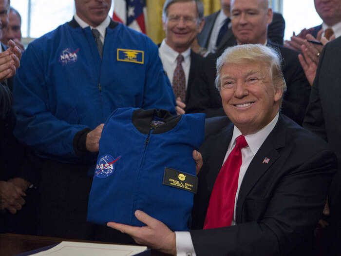 March 21, 2017: Trump receives a NASA flight jacket after signing the NASA Transition Authorization Act of 2017 in the Oval Office.