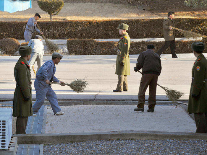 Outside, North Korean workers are employed to sweep the North