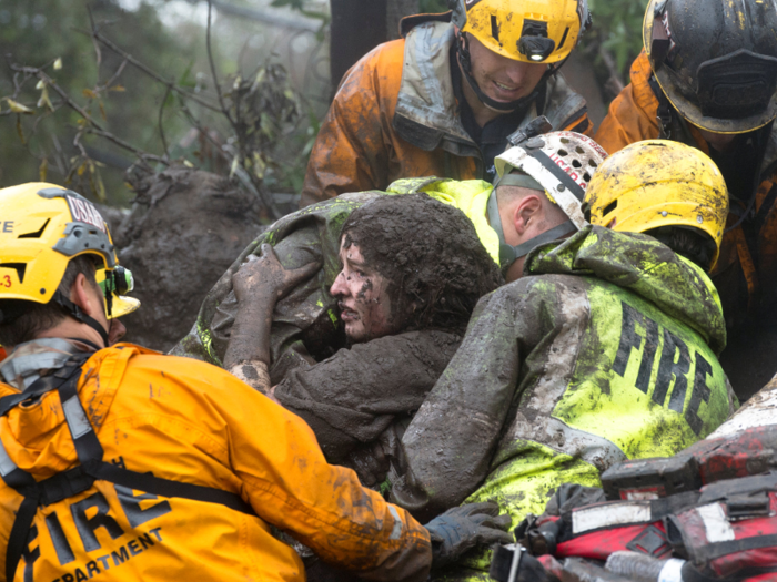 Trees were torn from their roots, houses and cars were destroyed, and people were covered in mud as debris surged down empty streets. This woman was caught up in the chaos, and had to be rescued from a collapsed house.