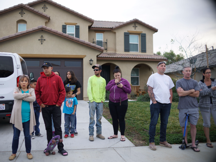 Stunned neighbors, many of whom denied knowing much about the family, lined the sidewalks to watch investigators scour the home.