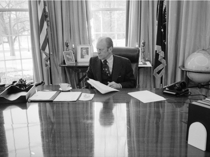 Despite the fact this photo was taken just as Gerald Ford prepared to vacate the White House, his desk still featured a number of stacks of papers and a cup and saucer.