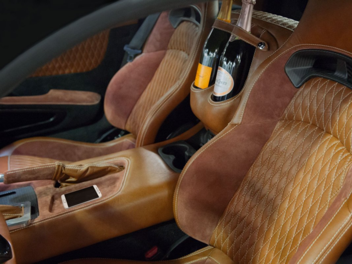 The car comes complete with high-end leather seats, champagne bottle holders, center console phone chargers, and a custom leather and suede sunglasses case.