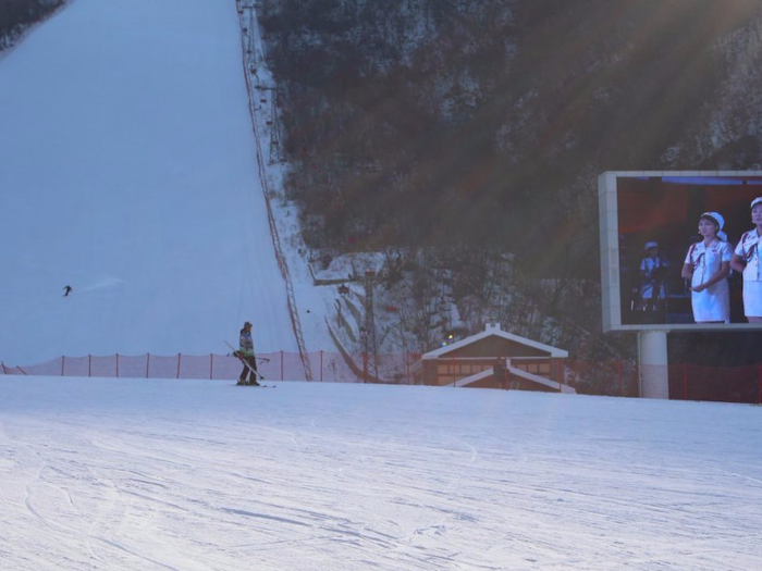 A TV screen at the bottom of the mountain plays videos for guests. There