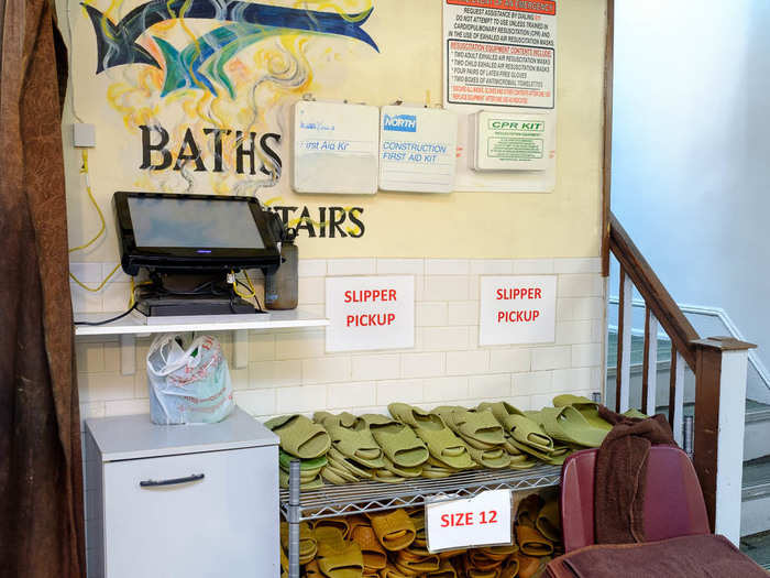 The baths are in the basement. Pick up some slippers — they come in two sizes, 9 and 12 — and head downstairs.