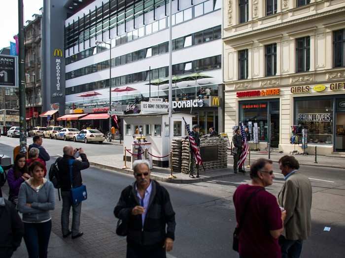 Today, Checkpoint Charlie still stands, but is a major tourist attraction. The former military checkpoint dividing the communist and capitalist worlds is flanked by a McDonald