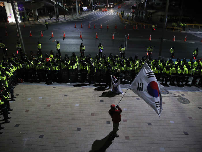 Around 80 anti-North Korean protestors who oppose making concessions for North Korea were staged outside. About 100 police officers were reportedly on the scene.