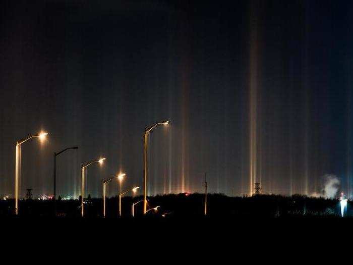 The crystals reflect natural and artificial light, and the light pillars take on the color of whatever is being reflected. Street lamps produced rays in yellow and orange hues.