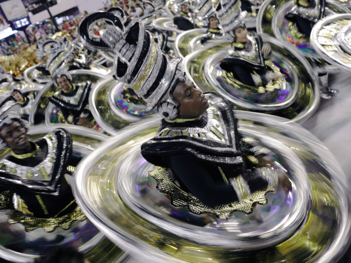 Performers from 13 samba schools make their way through the open-air stadium in presentations filled with music, dancing, and elaborate, over-the-top costumes and floats.