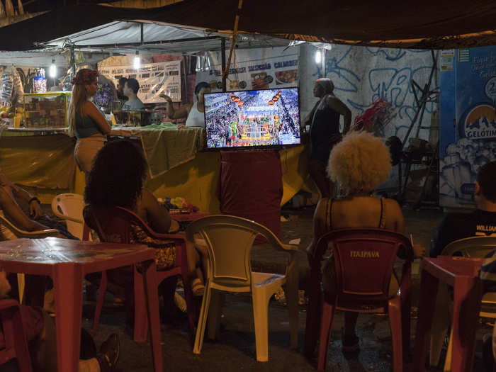 Outside the Sambadrome, locals watch the festivities on TV.