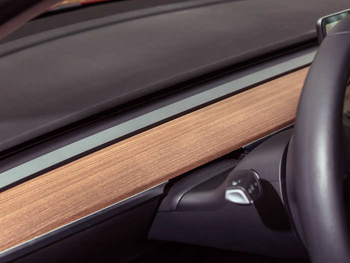 The open-grain wood and brushed metallic trim is the only real deviation from the black interior color.