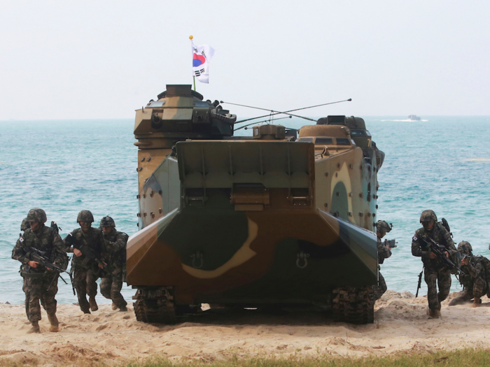 As they hit the beach, the Marines exit the protection of the armored vehicles and assault the beach on foot.