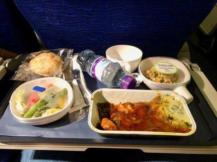 Dinner was a choice of chicken casserole in ale sauce with kale mashed potatoes, or farfalle pasta in tomato and mascarpone sauce. I went with the chicken. Although it was a tad salty, it was way beyond what you expect from economy-class airplane food. It also came with a small water bottle, a cup for coffee or tea (which followed), a roll...