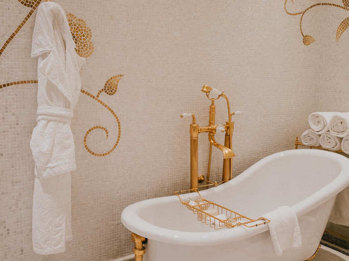 A claw foot, sloping bathtub with gold fixtures. You will enjoy this picture more if you imagine it filled with bubbles and a rubber ducky or two.