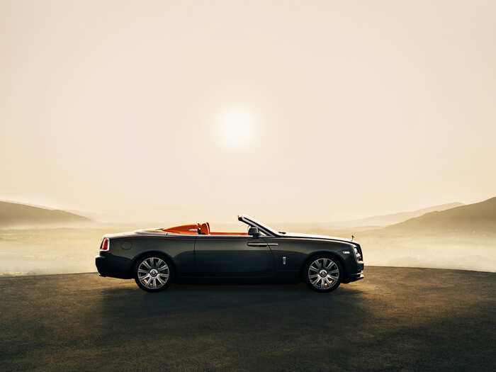 The Rolls Royce Dawn Aero Cowling is a two-seater convertible with a silver and tan color scheme. A carbon fiber "spine" is exposed to showcase the lightweight design. The interior features a contemporary chevron graphic.