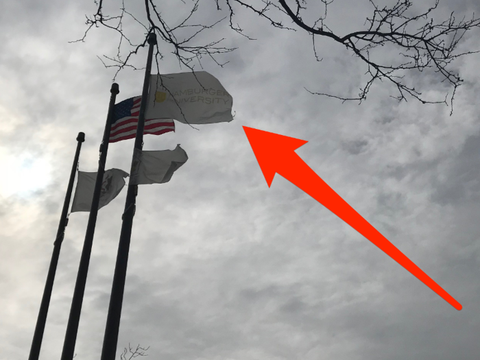 A "Hamburger University" flag flies alongside the American flag outside.