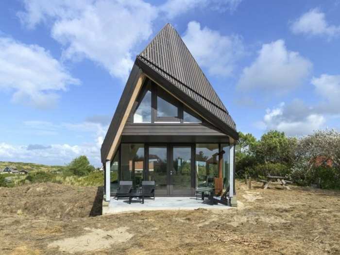 The bottom floor of the two-story house tucks into the hilly landscape.