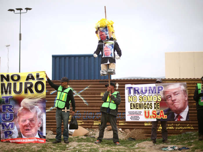 Protesters converged on both sides of the border — on the Mexican side in Tijuana, people hoisted up signs written in Spanish and what looked like a piñata resembling Trump.