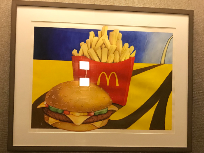 There are paintings that seem to be inspired by both pop art and hamburgers.